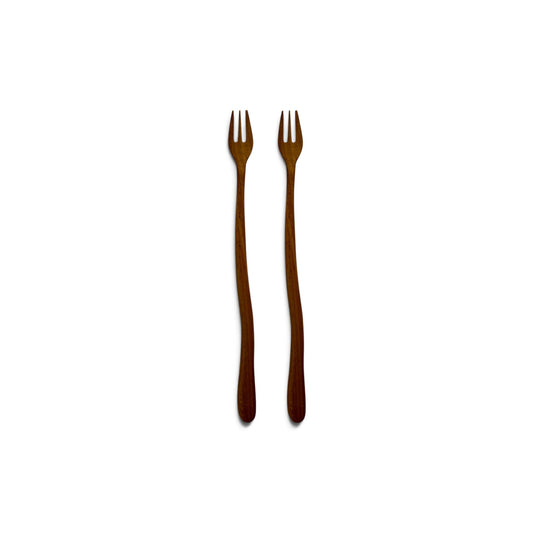 Pair of hand-carved teak wood appetizer forks with wavy stems side-by-side on a white background.