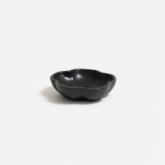 Hand-carved teak wood bowl with unique wavy edges and detailed natural wood grain.