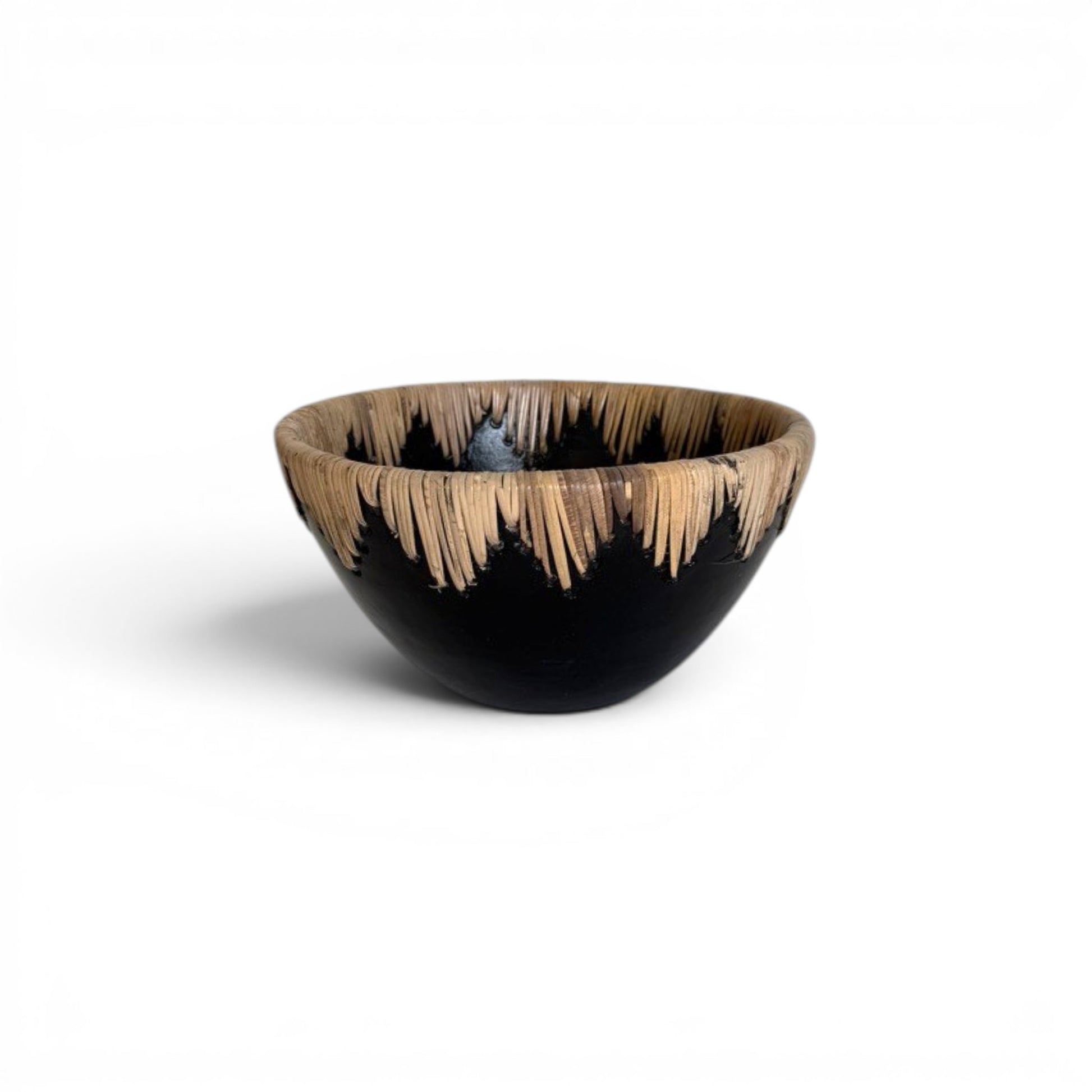 Large circular matte black terracotta decorative centerpiece bowl with a continuous crown border of stitched natural rattan fringe running along the inner and outer rim -Malta