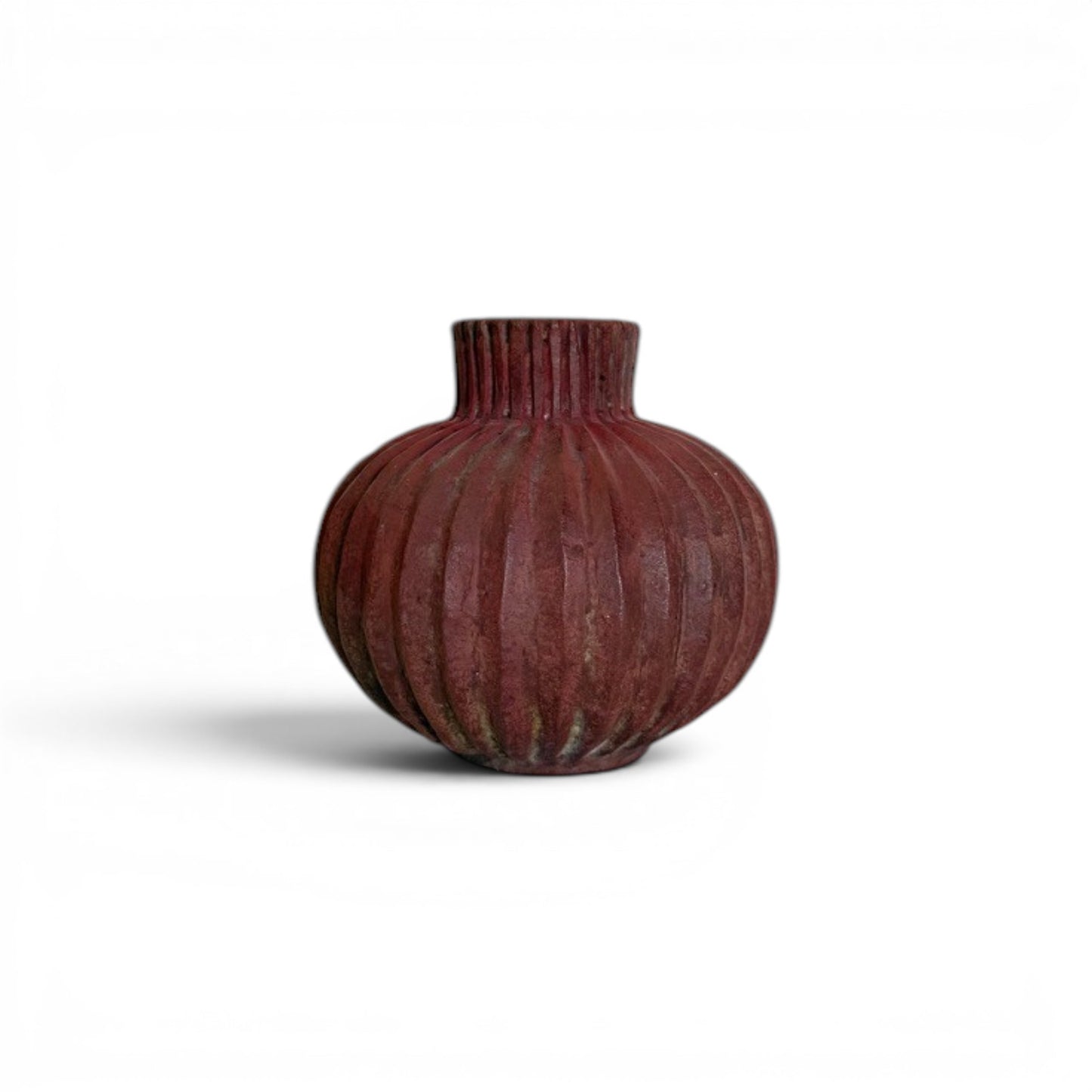 Compact, round earthy red terracotta vase with dense vertical fluted ridges running from the base up through the short neck to the rim.