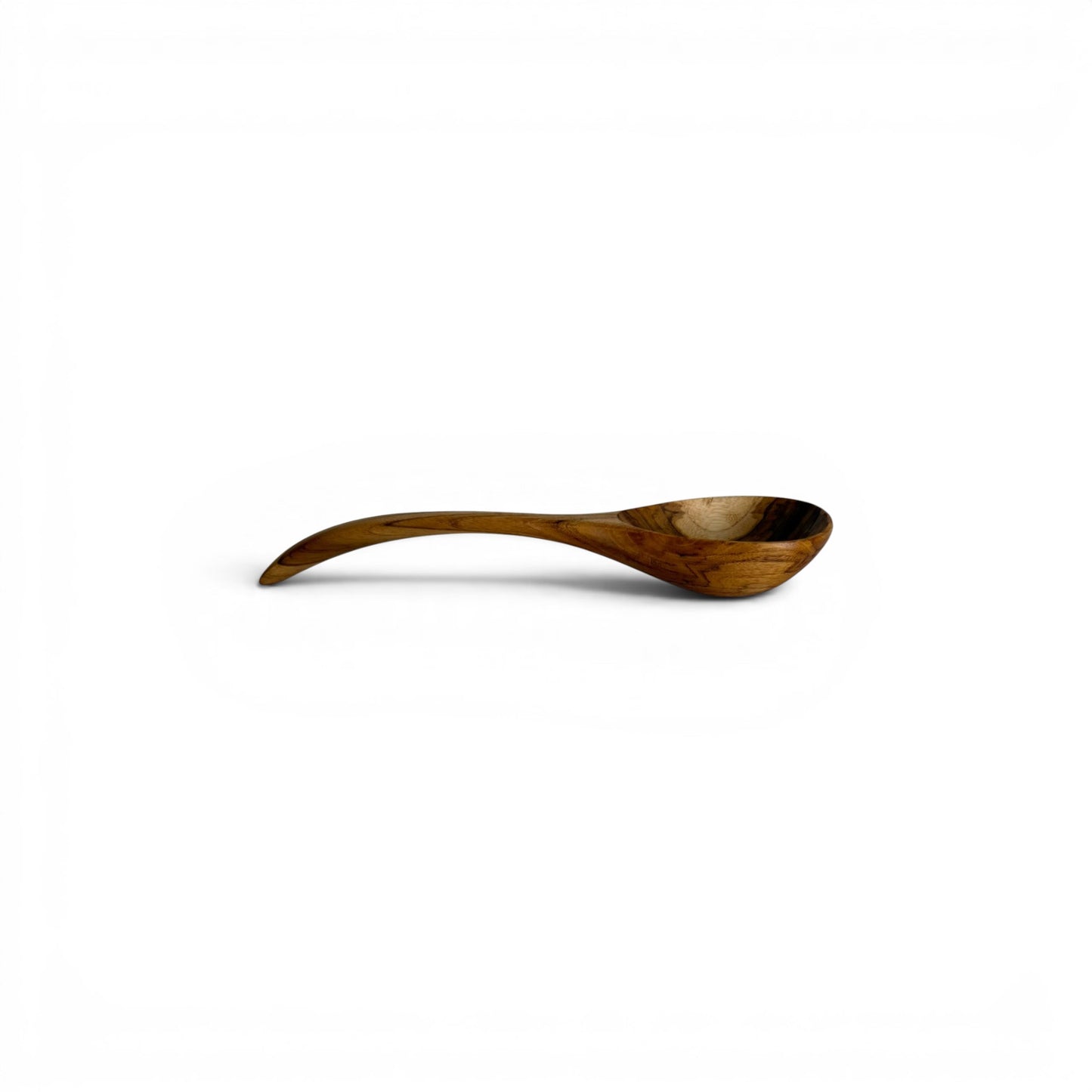 Side profile view of a hand-carved teak wood serving spoon showing an arched handle and deep scoop.