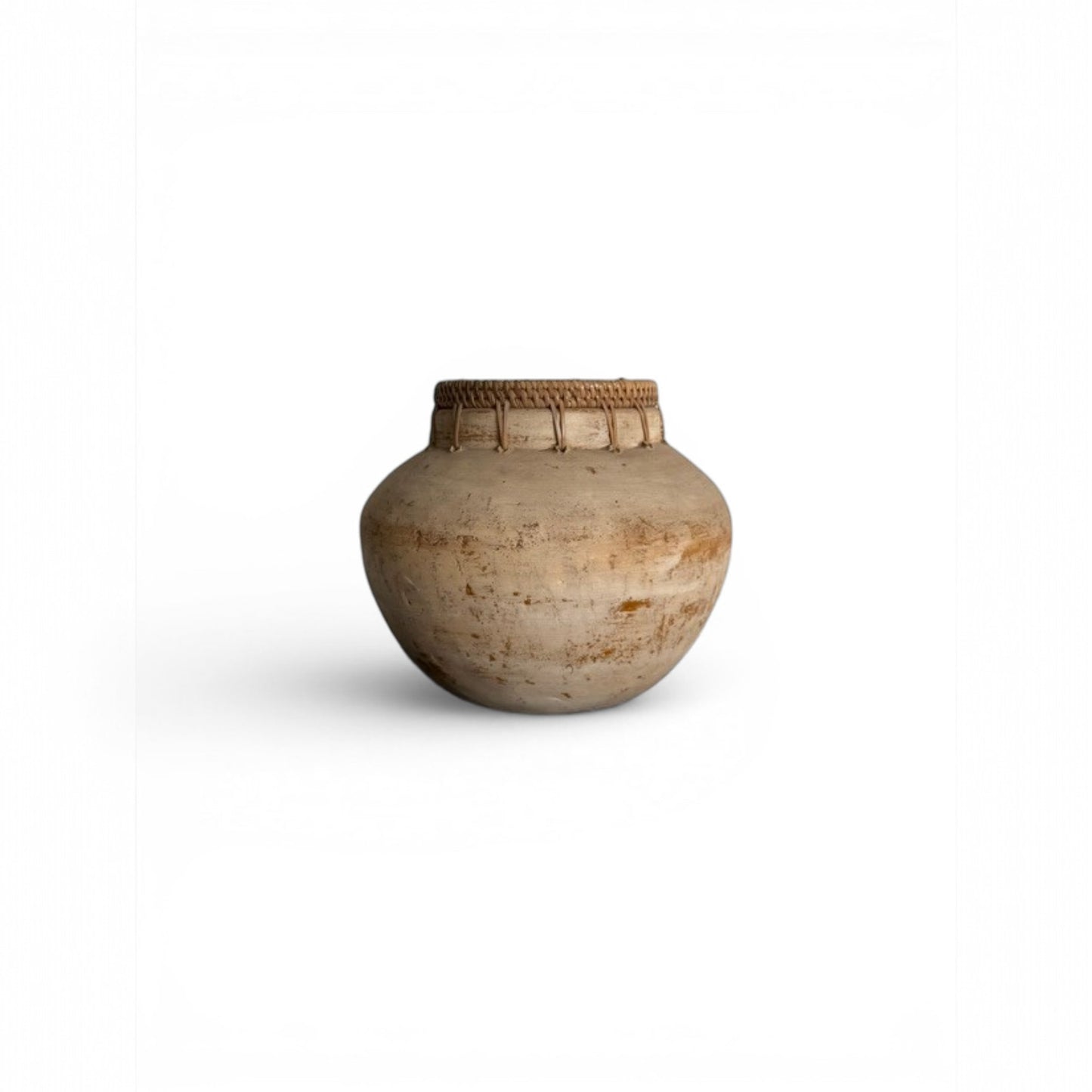A wide-bellied terracotta pot featuring a tactile woven rim detail. 